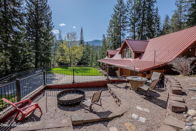 2264 Parker Canyon Rd, Bonners Ferry, ID 83805 - view of patio with a view of trees, fence, a mountain view, and an outdoor fire pit