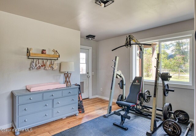 workout area with light wood-type flooring and baseboards