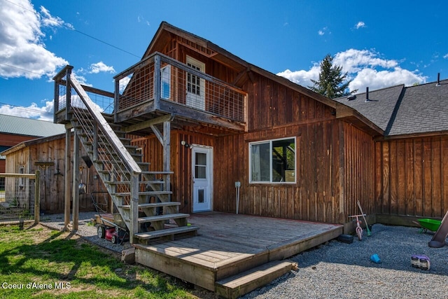 rear view of property featuring a wooden deck and stairway
