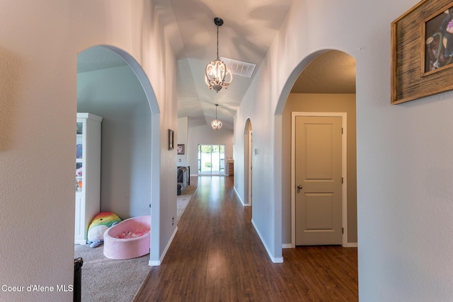 corridor with arched walkways, baseboards, and dark wood-style floors