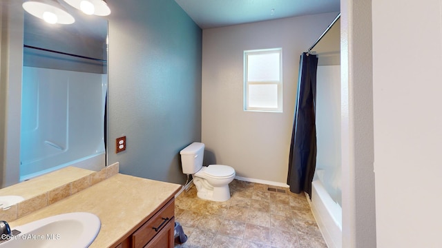 full bathroom featuring stone finish floor, shower / tub combo, vanity, baseboards, and toilet