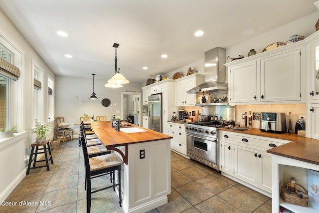1201 Paradise Valley Rd, Bonners Ferry, ID 83805 - kitchen featuring wall chimney range hood, butcher block countertops, stainless steel appliances, backsplash, and a sink