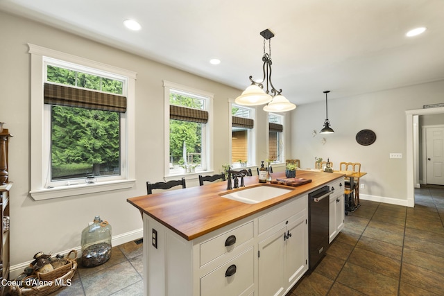 1201 Paradise Valley Rd, Bonners Ferry, ID 83805 - kitchen with butcher block countertops, black dishwasher, a sink, white cabinetry, and a center island with sink