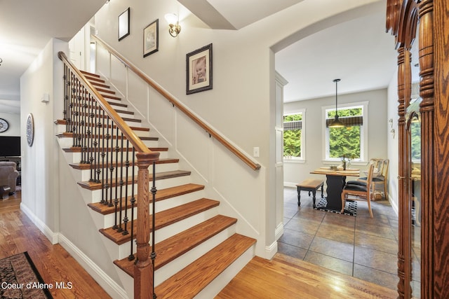 1201 Paradise Valley Rd, Bonners Ferry, ID 83805 - stairs featuring arched walkways, baseboards, and wood finished floors