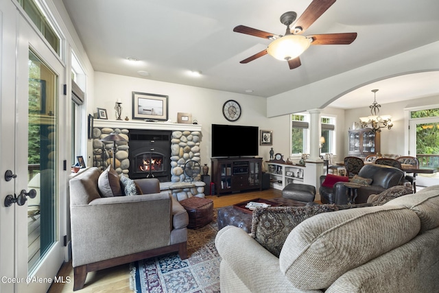 1201 Paradise Valley Rd, Bonners Ferry, ID 83805 - living area featuring arched walkways, ornate columns, wood finished floors, a fireplace, and a ceiling fan