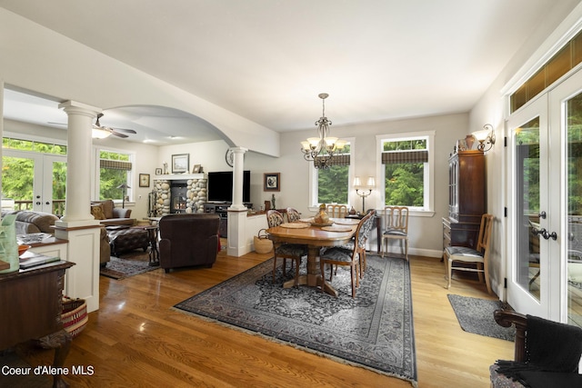 1201 Paradise Valley Rd, Bonners Ferry, ID 83805 - dining area featuring ornate columns, french doors, arched walkways, light wood finished floors, and a chandelier