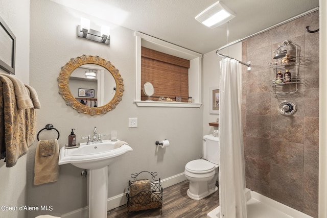 1201 Paradise Valley Rd, Bonners Ferry, ID 83805 - bathroom featuring toilet, wood finished floors, a stall shower, and baseboards