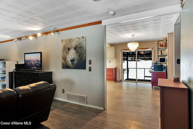 19856 B St Joe River Rd, Calder, ID 83808 - living room featuring a chandelier, rail lighting, visible vents, and wood finished floors