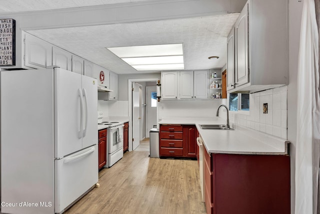 19856 B St Joe River Rd, Calder, ID 83808 - kitchen with open shelves, a sink, white appliances, light wood-type flooring, and under cabinet range hood
