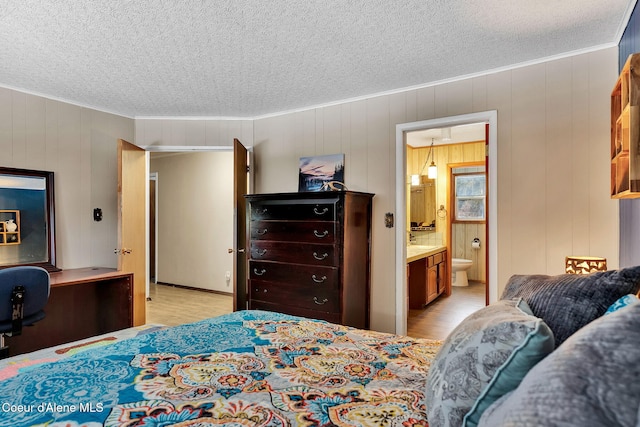 19856 B St Joe River Rd, Calder, ID 83808 - bedroom featuring crown molding, connected bathroom, a textured ceiling, and light wood-type flooring