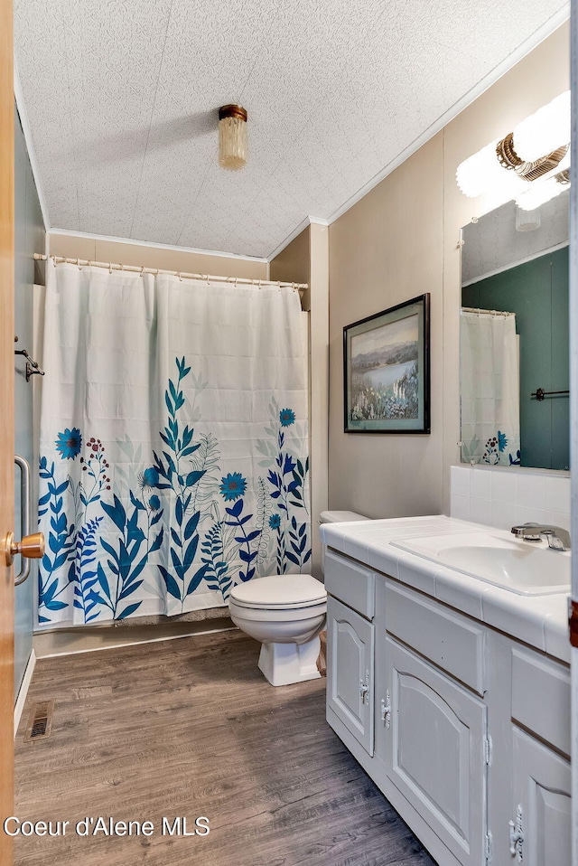 19856 B St Joe River Rd, Calder, ID 83808 - bathroom featuring visible vents, wood finished floors, vanity, toilet, and ornamental molding