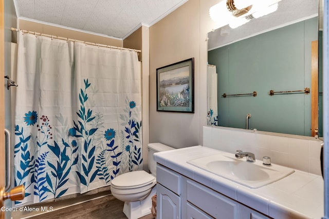 19856 B St Joe River Rd, Calder, ID 83808 - full bath with crown molding, vanity, toilet, wood finished floors, and tasteful backsplash