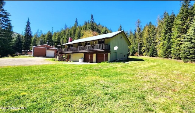 19856 B St Joe River Rd, Calder, ID 83808 - view of front of property featuring a deck, a front yard, a forest view, an outbuilding, and a detached garage