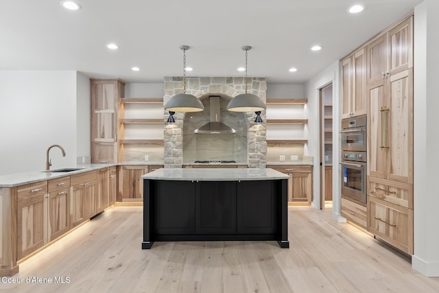 kitchen with wall chimney range hood, open shelves, a sink, and light wood-style floors