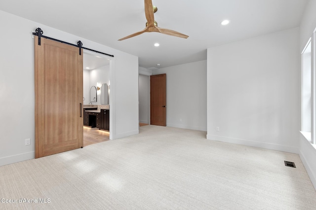spare room featuring visible vents, ceiling fan, recessed lighting, a barn door, and light colored carpet
