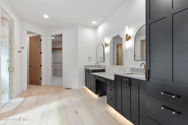 full bathroom featuring vanity, recessed lighting, baseboards, wood finished floors, and a stall shower