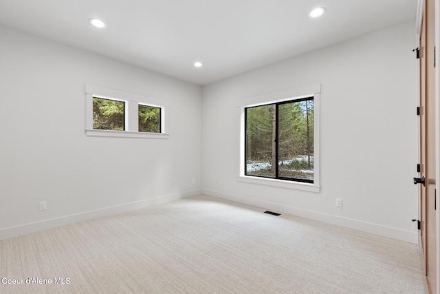 spare room with baseboards, carpet, recessed lighting, and visible vents
