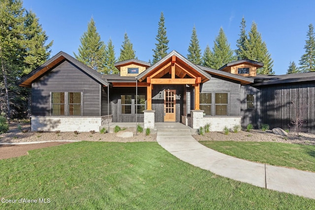 view of front of property with a front yard and stone siding