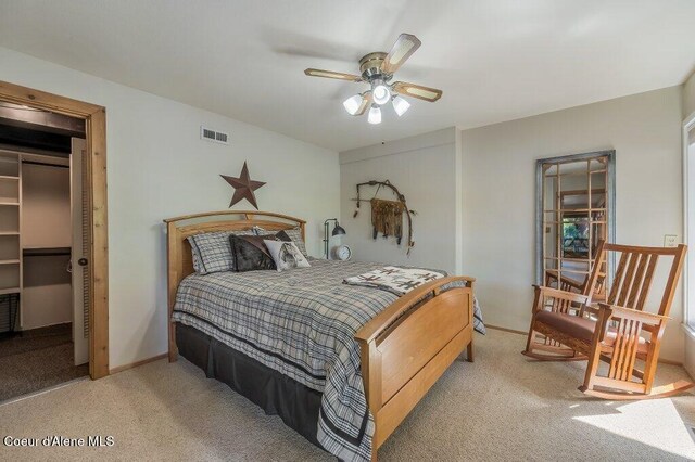 carpeted bedroom with ceiling fan and visible vents