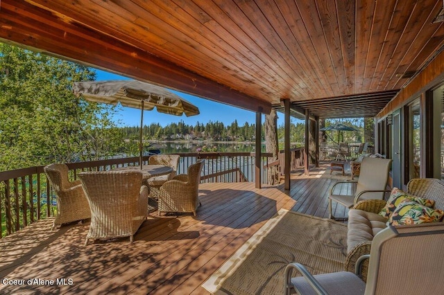 deck featuring a water view and outdoor dining area