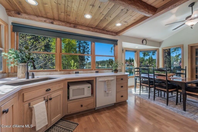 kitchen featuring white appliances, recessed lighting, light countertops, light wood-type flooring, and a sink