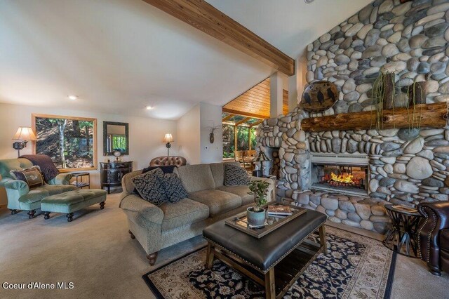 carpeted living area featuring lofted ceiling with beams, a wealth of natural light, and a fireplace