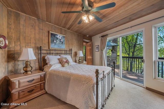 bedroom with wood walls, wooden ceiling, multiple windows, and access to exterior