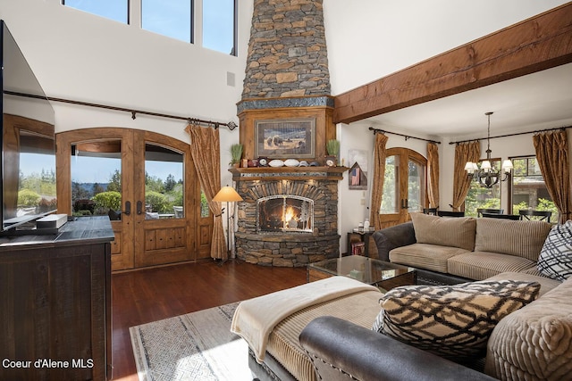 6012 W Quartzite Ln, Coeur Dalene, ID 83814 - living room featuring a high ceiling, a chandelier, french doors, a stone fireplace, and healthy amount of natural light