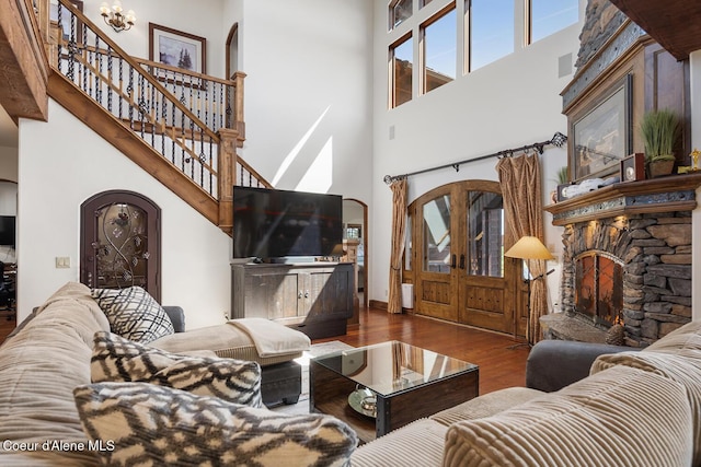 6012 W Quartzite Ln, Coeur Dalene, ID 83814 - living room with a high ceiling, a fireplace, wood finished floors, arched walkways, and stairs