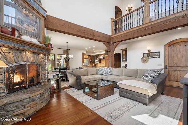 6012 W Quartzite Ln, Coeur Dalene, ID 83814 - living area featuring a towering ceiling, hardwood / wood-style flooring, a stone fireplace, recessed lighting, and a chandelier