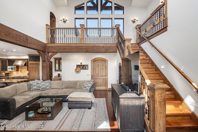 6012 W Quartzite Ln, Coeur Dalene, ID 83814 - living room featuring a towering ceiling, wood finished floors, arched walkways, and stairs