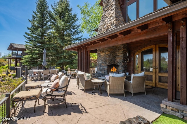 6012 W Quartzite Ln, Coeur Dalene, ID 83814 - view of patio with an outdoor stone fireplace, outdoor dining area, and french doors