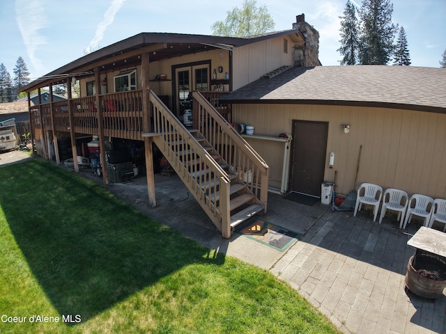 back of house featuring a wooden deck, a patio, french doors, a yard, and stairway