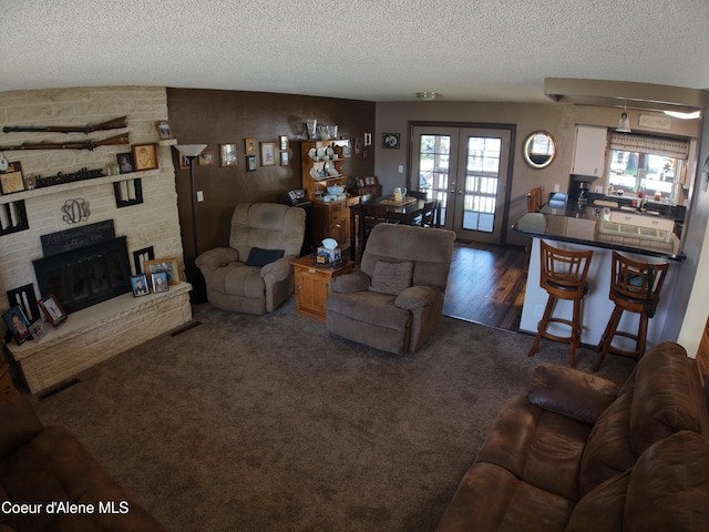 living area featuring french doors, a textured ceiling, and plenty of natural light