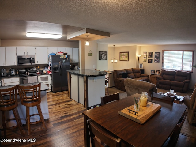 dining room featuring a textured ceiling and dark wood-style flooring