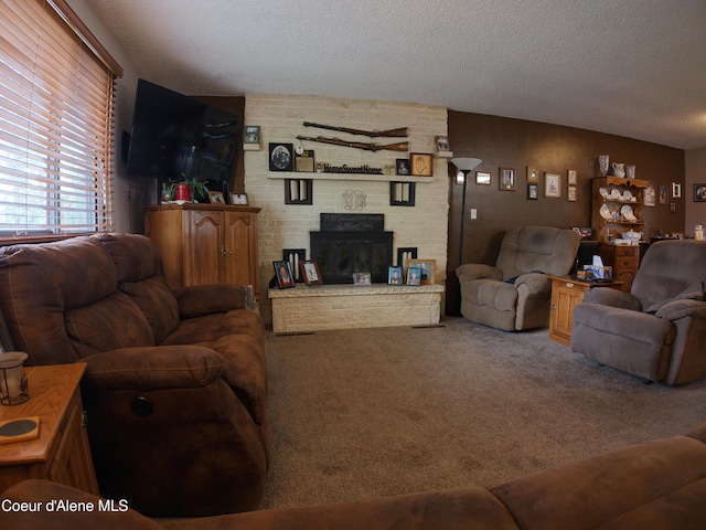 living area with a fireplace, carpet, and a textured ceiling