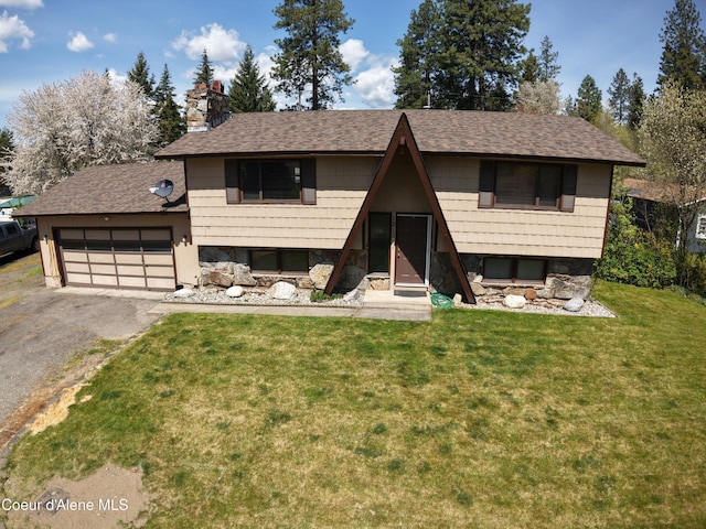 bi-level home featuring a garage, driveway, roof with shingles, and a front yard