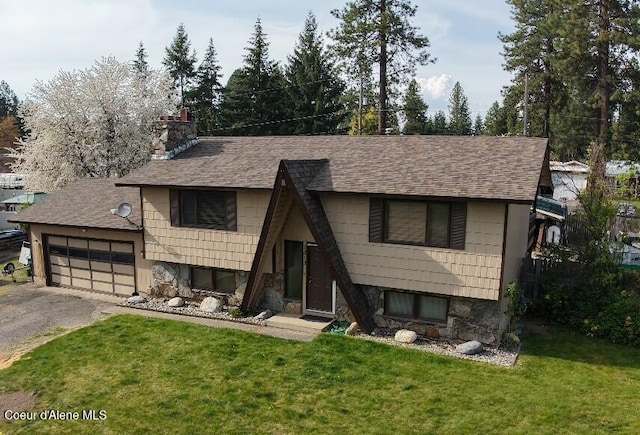 raised ranch featuring a garage, a shingled roof, a chimney, and a front yard