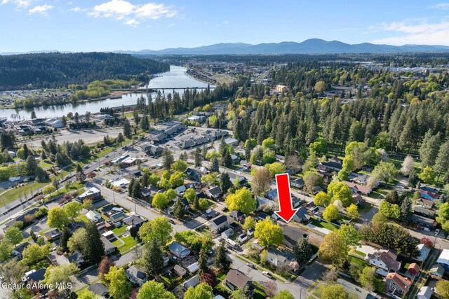 aerial view with a wooded view and a water and mountain view