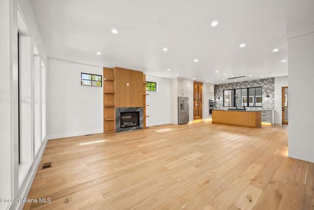 907 N B St, Coeur Dalene, ID 83814 - unfurnished living room featuring a premium fireplace, light wood-type flooring, recessed lighting, and baseboards
