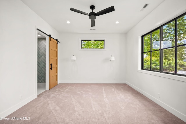 907 N B St, Coeur Dalene, ID 83814 - empty room featuring a barn door, light carpet, ceiling fan, baseboards, and recessed lighting