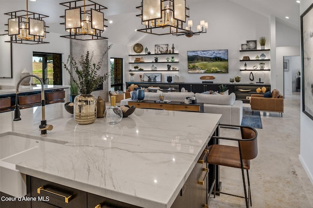 17056 S Lazurite Dr, Coeur Dalene, ID 83814 - interior space featuring finished concrete floors, hanging light fixtures, a sink, high vaulted ceiling, and a notable chandelier