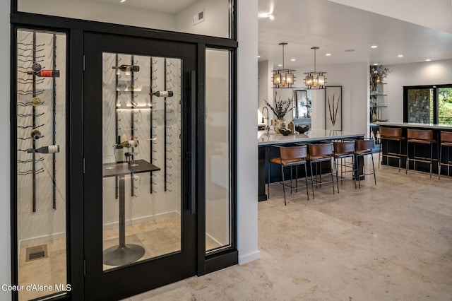 17056 S Lazurite Dr, Coeur Dalene, ID 83814 - wine room featuring an inviting chandelier, finished concrete flooring, recessed lighting, visible vents, and bar area
