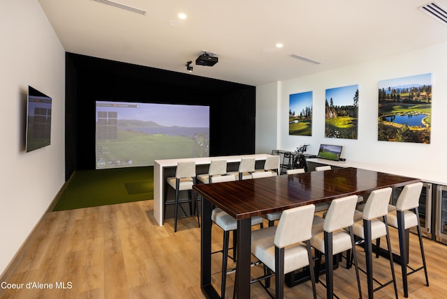 17056 S Lazurite Dr, Coeur Dalene, ID 83814 - home theater room featuring visible vents, light wood-style flooring, golf simulator, and wine cooler