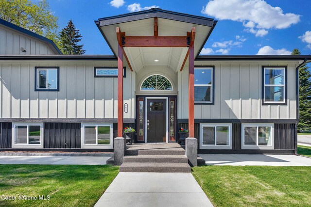 view of front of house with board and batten siding and a front lawn