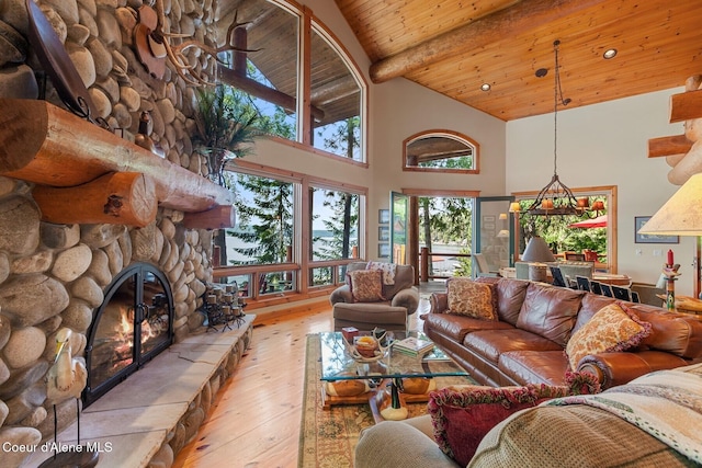 living room featuring beamed ceiling, a stone fireplace, high vaulted ceiling, hardwood / wood-style flooring, and wooden ceiling