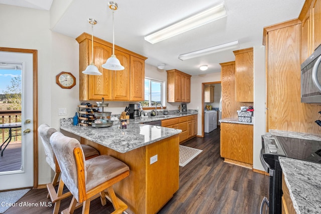 kitchen with a sink, a peninsula, light stone counters, electric stove, and dark wood finished floors