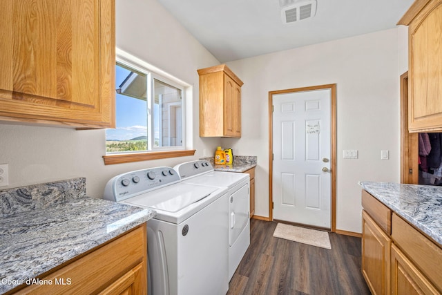 laundry room featuring visible vents, dark wood-style flooring, washer and dryer, baseboards, and cabinet space