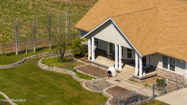 exterior space with a front yard, a gate, fence private yard, a patio area, and stone siding