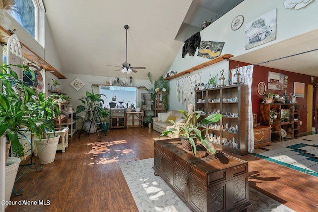 living area with ceiling fan, high vaulted ceiling, and wood finished floors